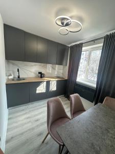 a kitchen with a table and chairs and a sink at Renovat si stilat pentru un sejur de exceptie in Ungheni