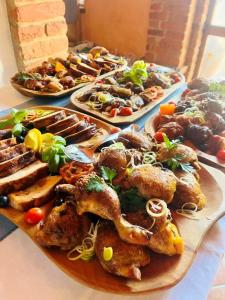 a table with several plates of food on it at St.Michael Panzió Lovaspark in Vasszentmihály