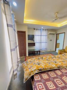 a bedroom with a bed with a yellow bedspread at Stay lux yellow in Islamabad