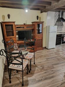 a kitchen with a glass table and a television at Apartamentos EL Wala in Hervás +16 photos