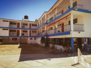 an apartment building with blue balconies and a parking lot at Hotel Caleta Bor Acapulco in Acapulco