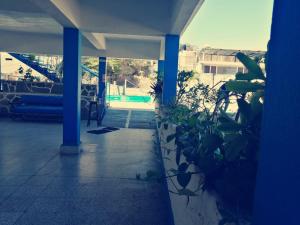 a room with a pool and blue columns and plants at Hotel Caleta Bor Acapulco in Acapulco