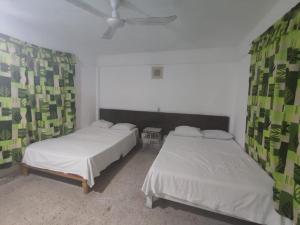 a bedroom with two beds and a ceiling fan at Hotel Caleta Bor Acapulco in Acapulco +19 photos