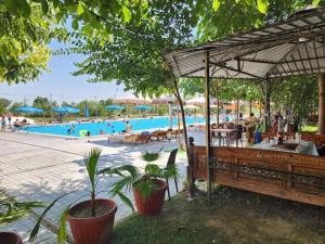 a pool with a bench and people at a resort at Room4you in Tashkent