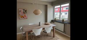a dining room with a wooden table and white chairs at Apartment Bergen Central - private balcony in Bergen