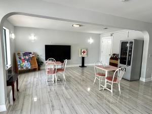 a living room with a table and chairs and a tv at Jubilee Inn in Biloxi