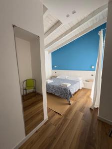 a bedroom with a mirror and a bed and a chair at affittacamere Villa Masá in Zingarello