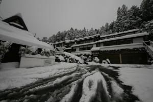 京都的住宿－湯溫泉奧哈拉山水酒店，一条被雪覆盖的街道,有一座建筑