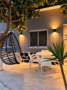 a patio with tables and chairs and a swing at Hotel Golden Oak in Ksamil