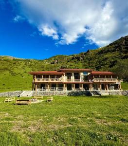 a large building in a field with a hill at Vardzia Hills in Gogasheni