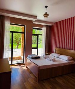 a bedroom with a large bed and a large window at Vardzia Hills in Gogasheni +6 photos