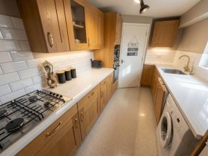 a kitchen with wooden cabinets and a stove top oven at Living light in Dallington