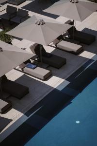 a group of umbrellas sitting next to a swimming pool at Magnus Hotel & SPA in Vlorë