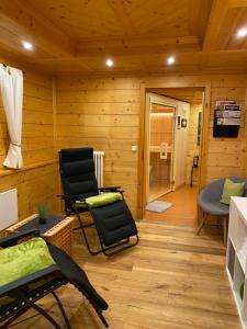 a living room with two chairs and a television at MEB Appartement, luxuriöses Appartement, im Chalet-Stil nur für Zwei, mit privater Sauna im Oberallgäu in Blaichach