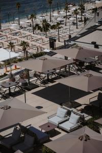 an overhead view of a beach with tables and umbrellas at Magnus Hotel & SPA in Vlorë