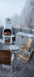 a patio with a fireplace and a table and chairs at Hagen Camping Mini hus in Kjerrvika