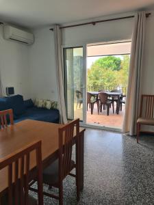 a living room with a blue couch and a table and a dining room at Apartament Santa Margarida in Roses