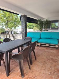 a patio with a blue couch and a table and chairs at Apartament Santa Margarida in Roses