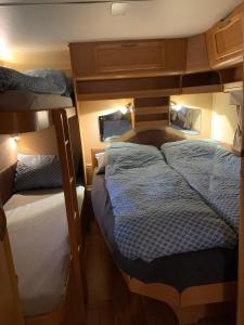 a small room with two beds and a bunk at Hagen Camping Mini hus in Kjerrvika