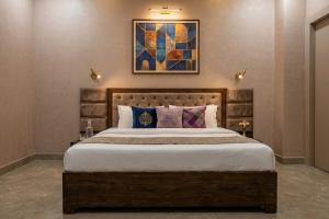 a bedroom with a large bed and a painting on the wall at Hotel Mounten View Near PEC & PGI in Chandīgarh +16 photos