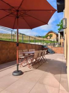 a table and chairs with an umbrella on a patio at Gîte de la Vonne in Vimines