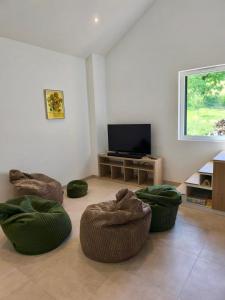 a living room with three ottomans and a television at Gîte de la Vonne in Vimines