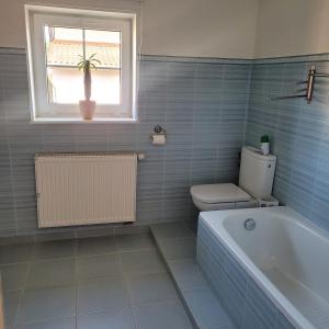 a bathroom with a tub and a toilet and a window at Słoneczne piętro w Kolbudach in Kolbudy +12 photos