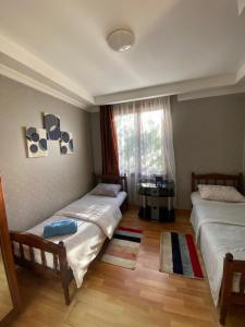 a bedroom with two beds and a window at Silk Way in Ureki
