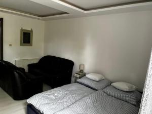 a bedroom with a bed and a black chair at Bezsó apartman in Hajdúszoboszló +13 photos