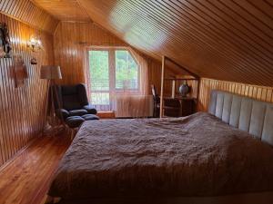 a bedroom with a bed and a chair and a window at Під Боржавою in Volovets