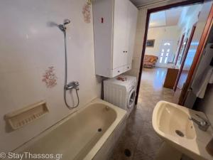 a bathroom with a bath tub and a sink at Apartment Lampiri in Limenaria +9 photos