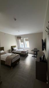 a bedroom with two beds and a table in it at Apartamenty Nadjeziorna in Ełk