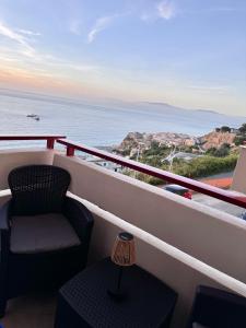 a balcony with a chair and a table and the ocean at Tramonto di Calabria in Pizzo