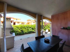 a table and chairs on a patio with an archway at Il Borgo Del Sole in Villasimius