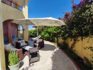 a patio with a table and an umbrella at Il Borgo Del Sole in Villasimius