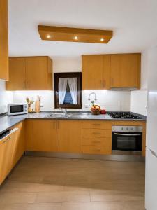 a kitchen with wooden cabinets and stainless steel appliances at Casa dos Laia in Sobreira Formosa