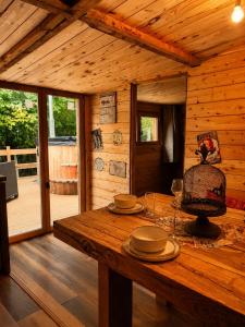 a wooden cabin with a wooden table with dishes on it at Les Ecuries du Ranch in Les Cresnays +35 photos