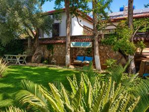 ein Haus mit einem grünen Garten mit Bäumen in der Unterkunft Hadrianus Pansion in Antalya