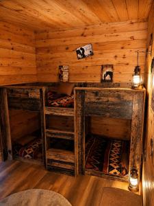 a room with three bunk beds in a log cabin at Les Ecuries du Ranch in Les Cresnays