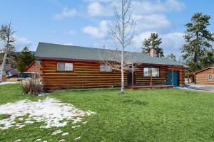 a log cabin with a green yard in front of it at Hummingbird Retreat in South Fork