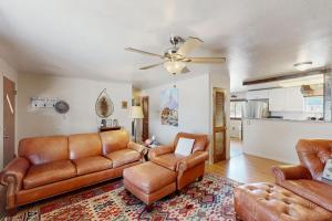 a living room with leather furniture and a ceiling fan at Hummingbird Retreat in South Fork