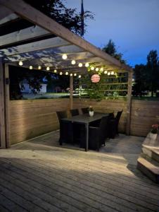 a patio with a table and chairs under a pergola at Villa Skäris in Falkenberg