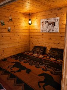 a bedroom with a bed in a wooden room at Les Ecuries du Ranch in Les Cresnays