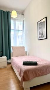 a bedroom with a bed with pink sheets and a window at Beautiful Rooms - Park Kasprowicza in Szczecin