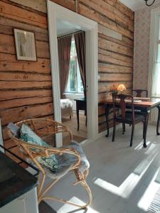 a room with a wooden wall with a table and a chair at Villa Matilda in Uusikaupunki