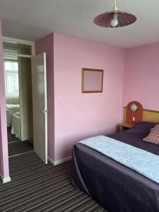 a bedroom with a bed and a pink wall at Villa 118 Dawlish Warren in Dawlish Warren