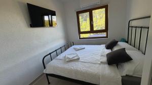 a bedroom with two beds with white sheets and a window at House RudNik in Silent Village, Island Krk in Isola Veglia