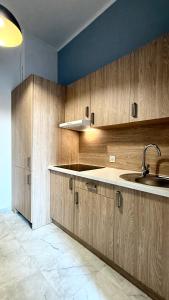 a kitchen with wooden cabinets and a sink at Beautiful Rooms - Park Kasprowicza in Szczecin
