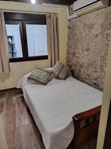 a bed in a room with two pillows on it at Apartamentos EL Wala in Hervás