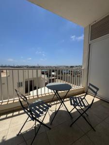 a table and chairs on a balcony with a view at Marsaxlokk Harbour View Apartment in Marsaxlokk